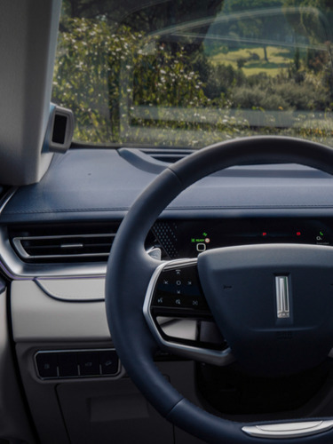 интериорен кадър на автомобил WEY 05, показващ гледната точка на водача към волана и инфоразвлекателния дисплей