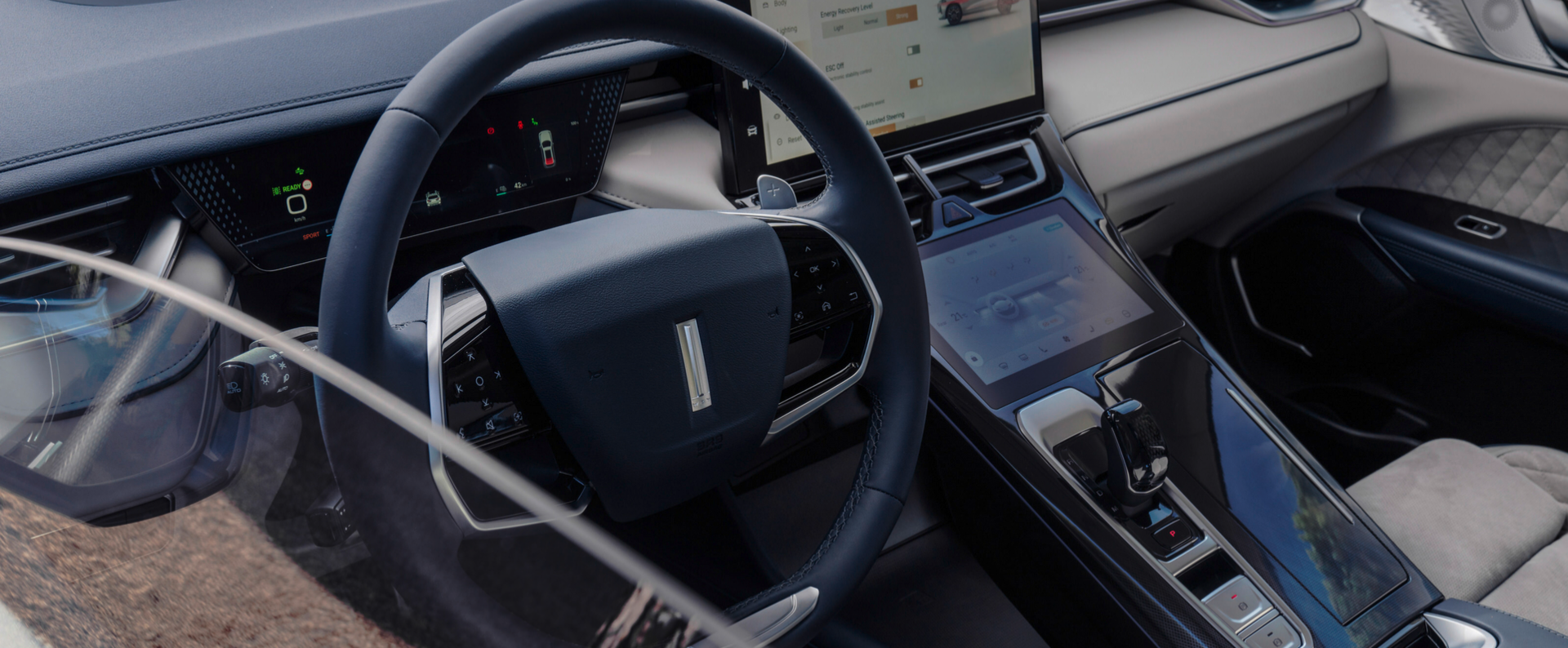интериорът на автомобила GWM WEY 05, показващ волана и инфоразвлекателния дисплей