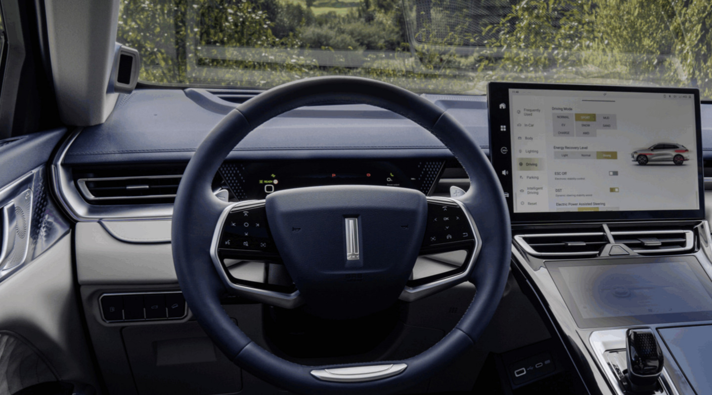 Интериорен кадър на автомобил Wey Coffee 01, показващ гледната точка на водача към волана и инфоразвлекателния дисплей
