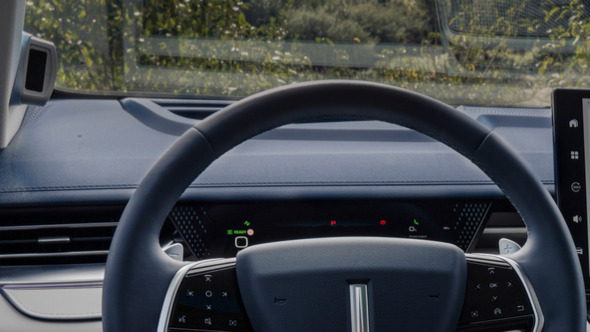 Интериорен кадър на автомобил Wey 05, показващ гледната точка на водача към волана и инфоразвлекателния дисплей